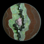Schorl Schism <br>
18" diameter, 2012 <br>
Purple calcite crystal cluster, black tourmaline crystals, fuchsite with rubies, red marble A circular painting of green and brown rocks.