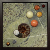 Ammonite Sampler III <br>
13" x 13", 2014 <br>
Marble; spheres of jasper, mookaite, serpentine, jasper, orbicular jasper, tiger’s eye; creedite crystal; fossil ammonite; fossil trilobite A group of balls and rocks on the ground.