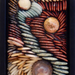 Pebbles IV: Unraveled<br>
7" x 10.4", 2016 <br>
Spheres of septarian nodule, orbicular jasper, brown agate <br>
Tiger's eye, bronzite, red tiger's eye, obsidian, picture jasper, aventurine, red jasper, poppy jasper, rain forest jasper, yellow jasper, mookaite A picture of some shells and rocks in a box.
