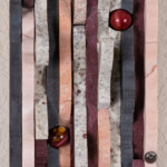Waves VIII: The Secret Within<br>
5.25” x 10.5”, 2018 <br>
Marble, grey slate, granite, limestone, syenite, mookaite spheres A close up of the door with some red balls