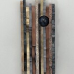 Waves XIII: Eye of the Planet <br> 13 1/2" x 4 3/4" x 2 3/4", 2019 <br> Sandstone, marble, conglomerate, limestone, quartzite, syenite, slate, granite <br> Sphere: dumortierite; Discs: quartzite A wall hanging made of wood and metal.