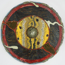 A circular painting of a black, yellow and red circle.