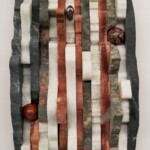 Waves IV: Peak and Valley <br>
5.5” x 9”, 2018 <br>
Serpentinite, marble, metasomatite, travertine, jasper spheres, obsidian cabochon A stone sculpture with red, white and black stripes.