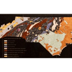 North Carolina Geologic Map in Stone
19 ¼” x 47 ½” x 1 ½”, 2019
Stones: Marble, syenite, sodalite syenite, granite, gabbro
Specimens: Calcite, pyrite in schist, pyrophyllite, gold in quartz, rutile, amethyst scepter, almandine garnet in schist, emerald, tourmaline, kyanite, ruby, fossil shark tooth, turtle shell, coral A geologic map of the state of north Carolina created with different colored stones
