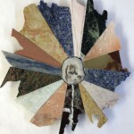 Triangles II: Radial Rose <br> 11.75” x 10”, 2021 <br> Syenite sodalite, alabaster, marble, metasomatite, onyx, quartzite, sandstone A circular picture of different colors and shapes.