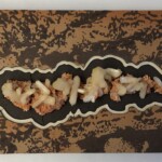 Pocket XXI: Otherworldly Words <br> 8.125” x 18.0”x 2.25”, 2022 <br> Crystals: orange heulandite with stilbite
Slabs: ferruginous silicified shale (printstone), marble, slate A black and brown tray with food on it