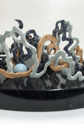 Sculpture V: From The Deep <br> 8.25” x 18” x 9.75”, 2022 <br> Marble, travertine, sodalite syenite; spheres of moonstone with quartz, chrysocolla, blue quartz A black plate with some blue and brown shapes