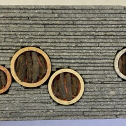 A brick wall with four circular holes in it.