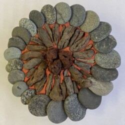 A round sculpture made of rocks and clay.